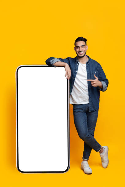 istock Positive arab guy with huge smartphone with blank screen 1325281964