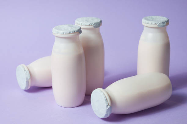 istock Bottles with probiotics and prebiotics dairy drink on light purple background. 1325282476