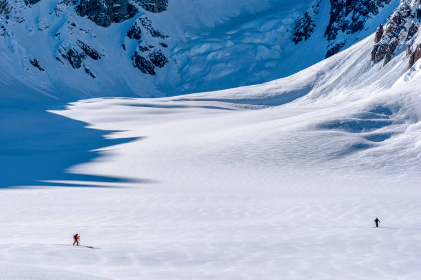 esquiadores de fondo escalan las rocosas nevadas canadienses - determination telemark skiing exploration winter fotografías e imágenes de stock