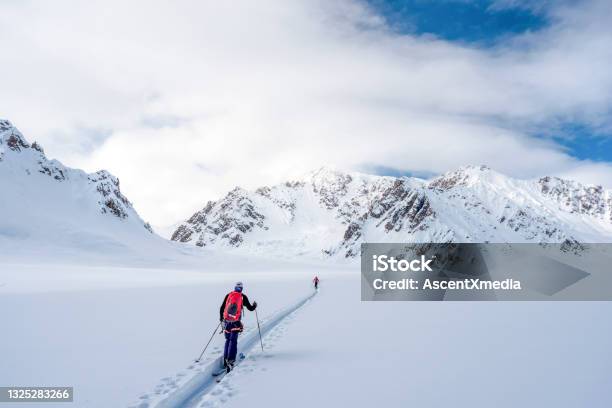 Backcountry Skiers Climb Snowy Canadian Rockies Stock Photo - Download Image Now - Skiing, Telemark Skiing, Back Country Skiing