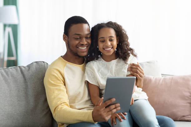 istock Happy black dad and daughter using digital tablet together 1325283428