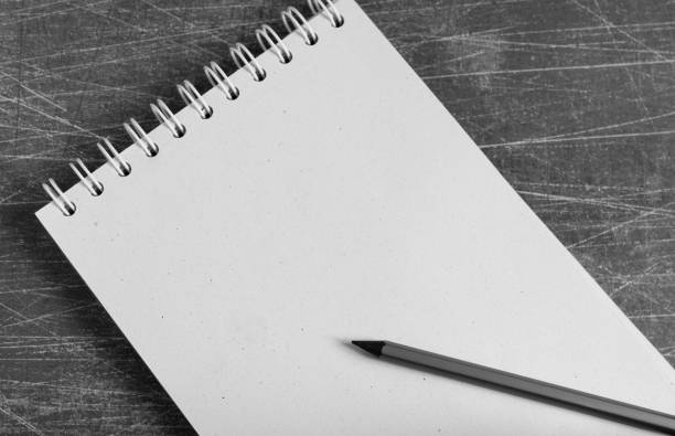View from above of empty blank notebook on gray background with pencil on it.
