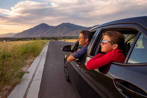 A father and his son enjoy driving their new vehicle and enjoying the scenic Utah sunset.