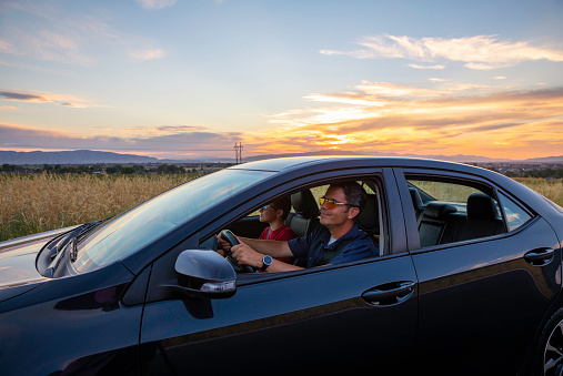 A father and his son enjoy driving their new vehicle and enjoying the scenic Utah sunset.