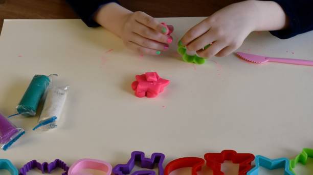 istock Toddler hands playing colorful play dough with plastic molds 1325289805