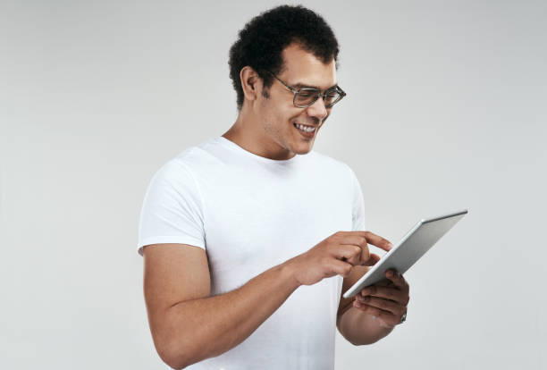 istock Shot of a man using a digital tablet while standing against a grey background 1325290172