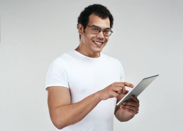 istock Shot of a man using a digital tablet while standing against a grey background 1325290174