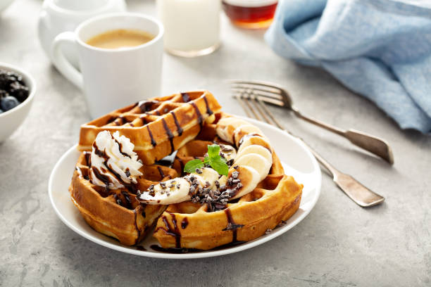 waffeln zum frühstück mit bananen und schokolade - waffle stock-fotos und bilder