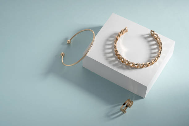 istock Golden bracelets and ring on white box on blue background 1325291384