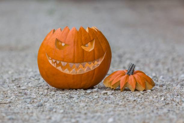 istock Scary smiling halloween pumpkin with nasty face on ground 1325293744