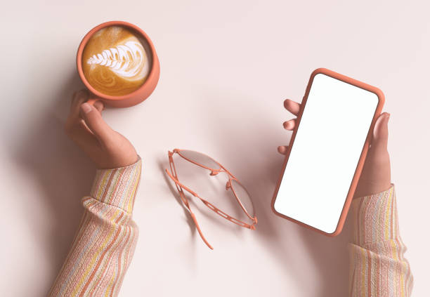 Woman holding a smartphone with the blank screen on cream color desk and drink coffee.