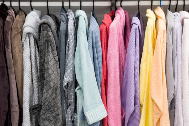 albornoces de diferentes colores en la percha en el cuarto de baño, en la tienda o en el mercado - towel hanging bathroom railing fotografías e imágenes de stock