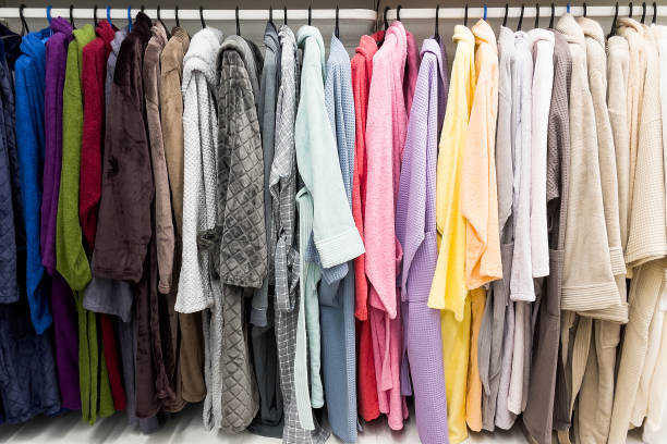 albornoces de diferentes colores en la percha en el cuarto de baño, en la tienda o en el mercado - towel hanging bathroom railing fotografías e imágenes de stock