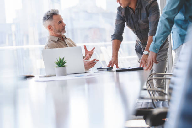 istock Three businessmen working and talking in a board room. 1325306870