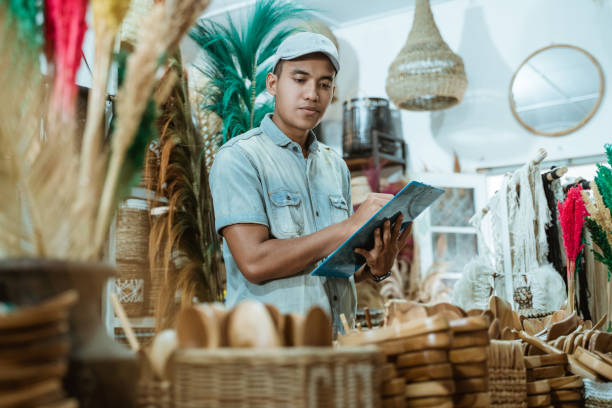 man holds the clipboard while checking items among craft items - fake rattan imagens e fotografias de stock