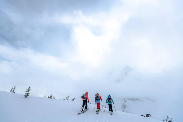 backcountry-skifahrer durchqueren am morgen die schneepiste - telemark skiing stock-fotos und bilder