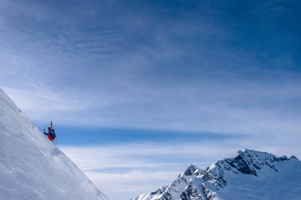 istock Backcountry skier hikes up snowy mountain slope 1325314277