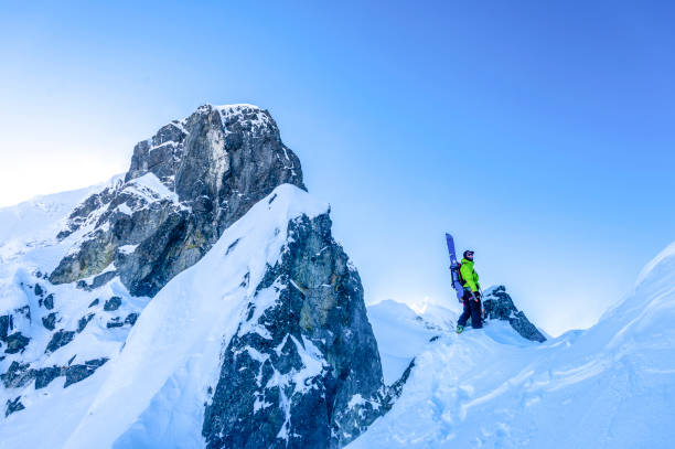 istock Backcountry skier hikes to snowy mountain peak 1325314287