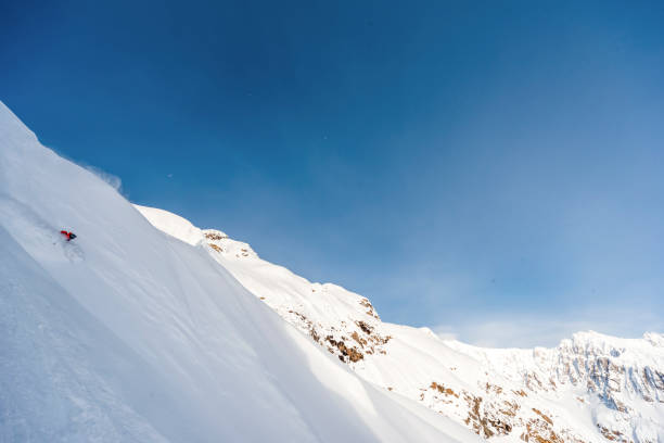 istock Extreme skier descends mountain through powder snow 1325315070