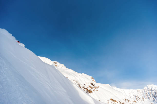 istock Extreme skier descends mountain through powder snow 1325315073