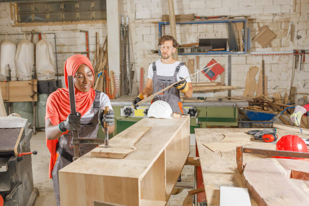 istock An Experienced Carpentry Worker and His Female Muslim Coworker are Using a Clamp While Working in a Large Workshop. 1325315094
