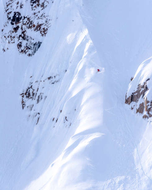 istock Extreme skier descends snowy mountain ridge 1325315285