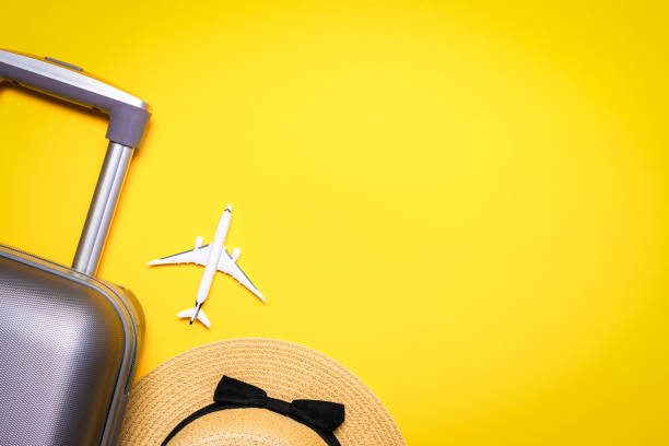 istock Summer pattern background. Suitcase, sunglasses with palm leaves and straw hat, white plane in travel composition on yellow background. Top view, flat lay. Copy space. 1325315398