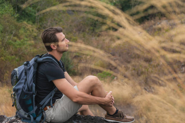 istock caucasian backpack hiker sitting on rock for resting during walking on trekking trail on mountain on summer sport journey leisure 1325317648
