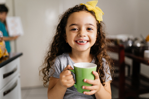 Little girl holding a green mug