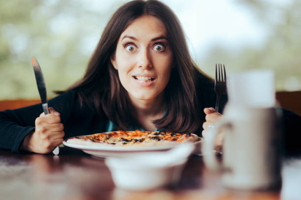 istock Hungry Woman with Fork and Knife Ready to Eat Pizza 1325324708