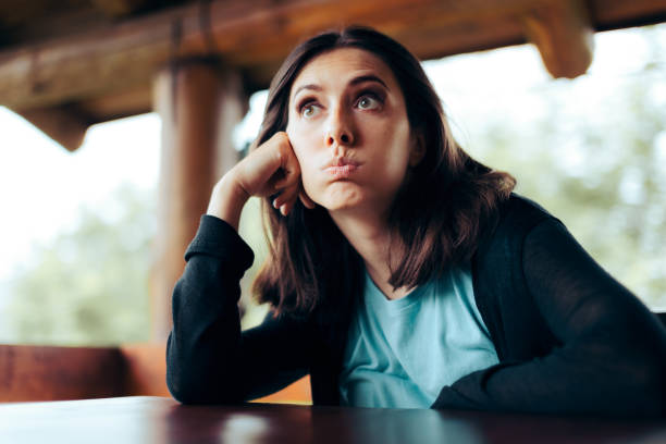 Sad Upset Woman Waiting Alone in a Restaurant Being Stood up Bored unhappy customer feeling hungry waiting for her order in a diner impatient stock pictures, royalty-free photos & images