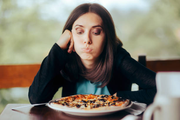 istock Sad Woman Looking at the Pizza in Her Plate 1325324724