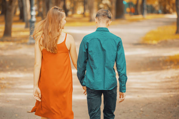 istock beautiful young couple walking in the park holding hands 1325324726