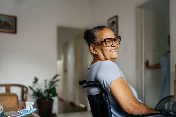 donna anziana felice sulla sedia a rotelle - sedia a rotelle foto e immagini stock