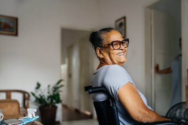 mulher idosa feliz na cadeira de rodas - 70 anos - fotografias e filmes do acervo