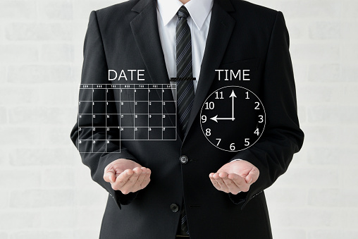 Business man showing calendar and clock