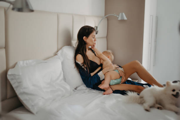 istock mother breastfeeding baby in bed with a dog 1325328205