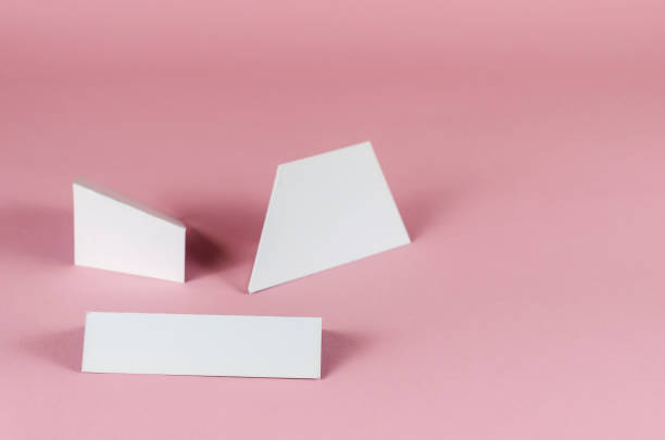istock White abstract geometric shapes on pink background. Three random geometric shapes on a colored background with shadows. 1325330398
