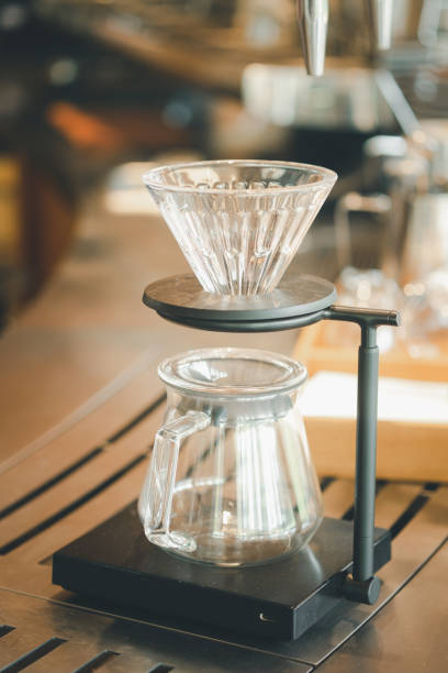 istock Coffee dip tools with coffee dropping from dip cone into the glass jar in coffee shop 1325334393