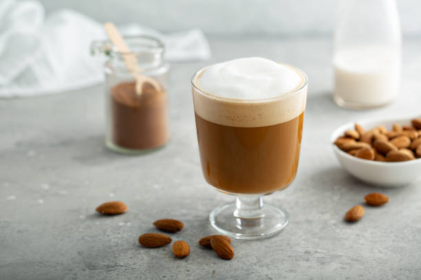 Almond milk latte in a glass Almond milk latte with thick foam in a glass milk froth stock pictures, royalty-free photos & images