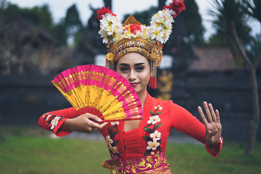 A young Bali female dancer is performing the Ramayana dance in a temple of Bali, in Indonesia.
