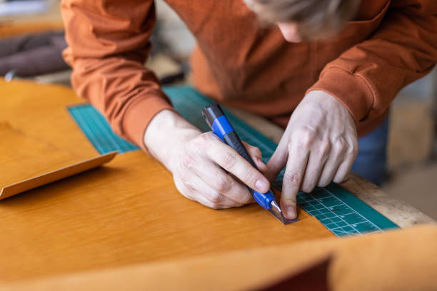 istock Male tanner making cutting scheme of bag working at leather workshop. Handcrafted creating 1325336993