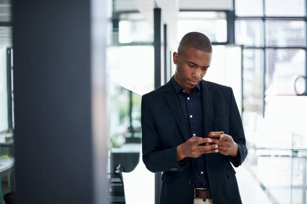 istock Shot of a young businessman using a smartphone in a modern office 1325337800