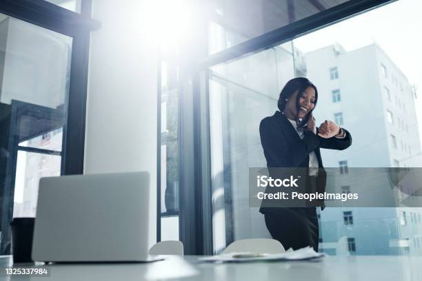 Shot Of A Young Businesswoman Using A Smartphone And Checking The Time In A Modern Office Stock Photo - Download Image Now