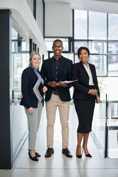 Portrait of a group of businesspeople working together in a modern office Winning is possible and it all starts with the team men standing business formalwear stock pictures, royalty-free photos & images