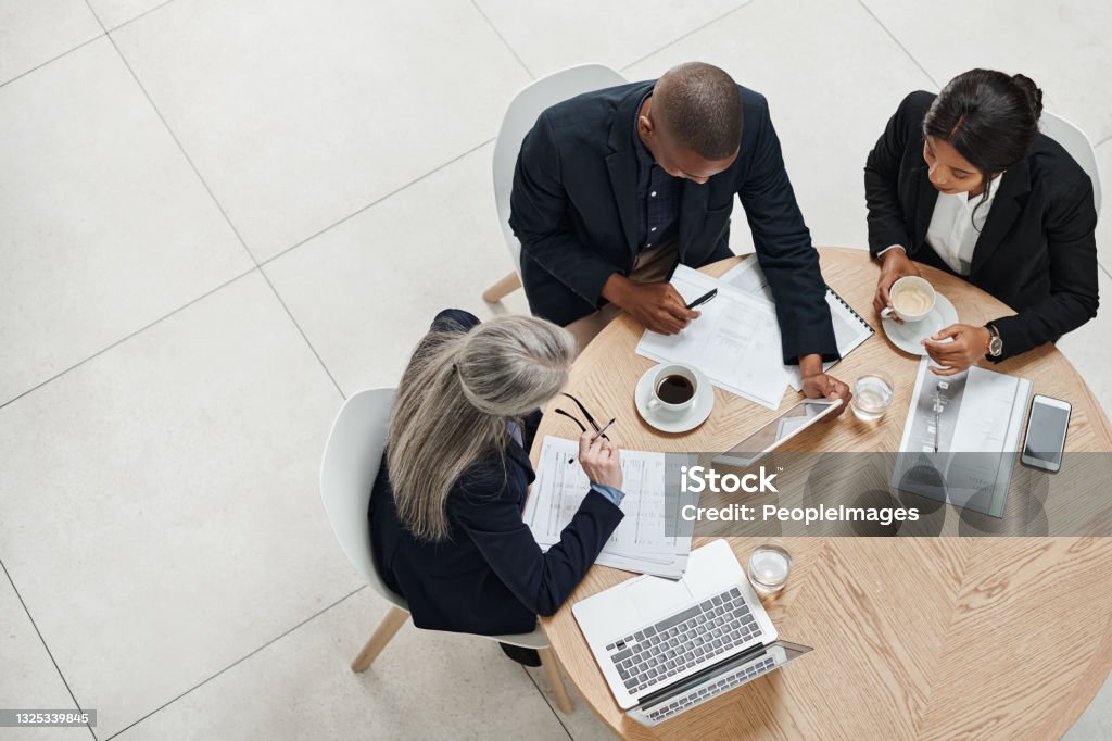High angle shot of a group of businesspeople having a meeting in a modern office Working as one is work well done Audit Stock Photo
