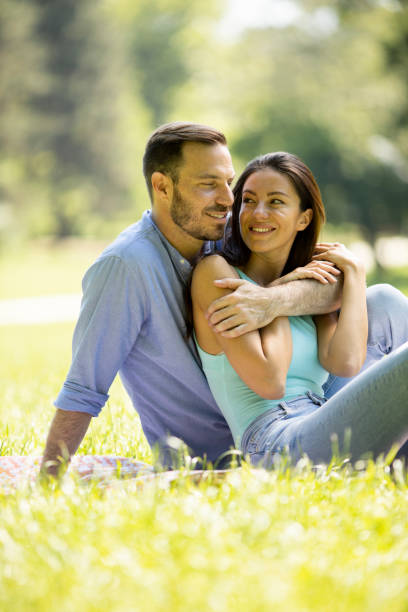 istock Affectionate young couple sitting on the green grass 1325343460