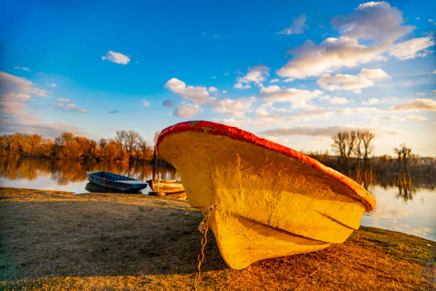 View at old yellow boat on the ground by the lake