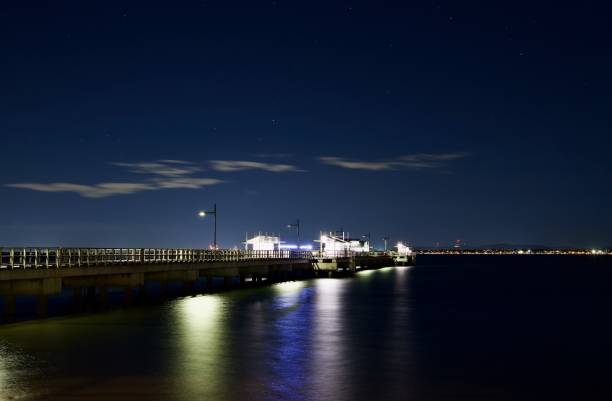 istock Starry Night, Pier and City Views over the bay 1325347332