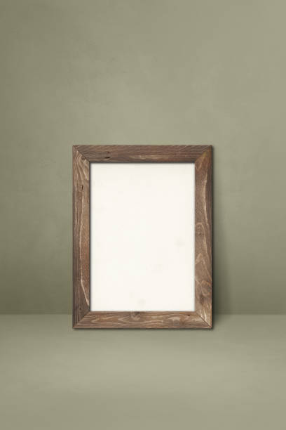 istock Wooden picture frame leaning on a grey wall 1325349403